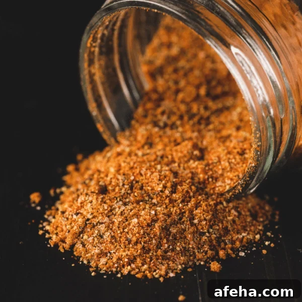 Pork chop seasoning pouring out of a glass container.