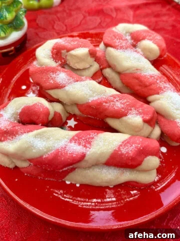 Christmas candy cane cookies stacked on a plate.