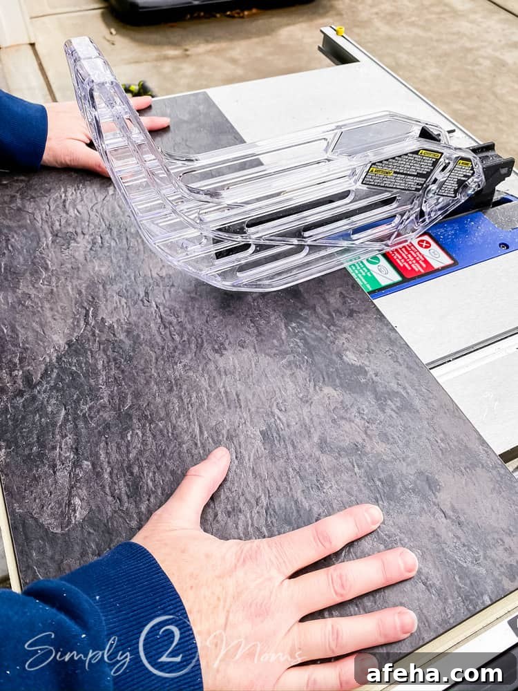 hands cutting vinyl floating floor tile on table saw