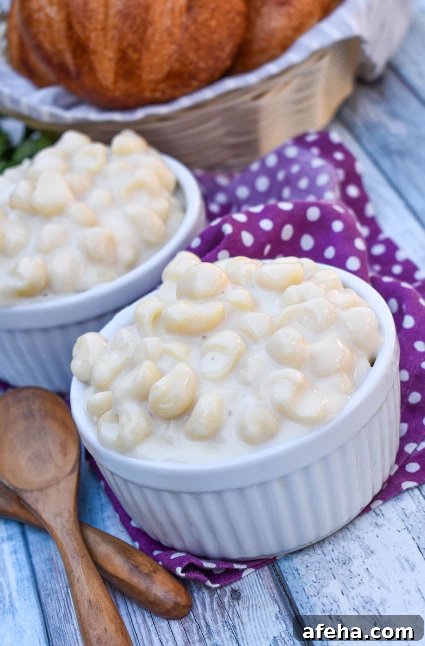 Panera Mac and Cheese Copycat Recipe: Creamy, Restaurant-Style 6 white cheddar mac and cheese in two white ramekins with a basket of crusty rolls in the background