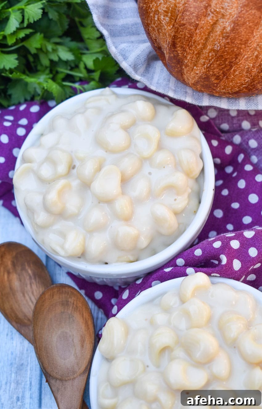 Panera Mac and Cheese Copycat Recipe: Creamy, Restaurant-Style 7 white cheddar mac and cheese in two white ramekins with a basket of crusty rolls in the background