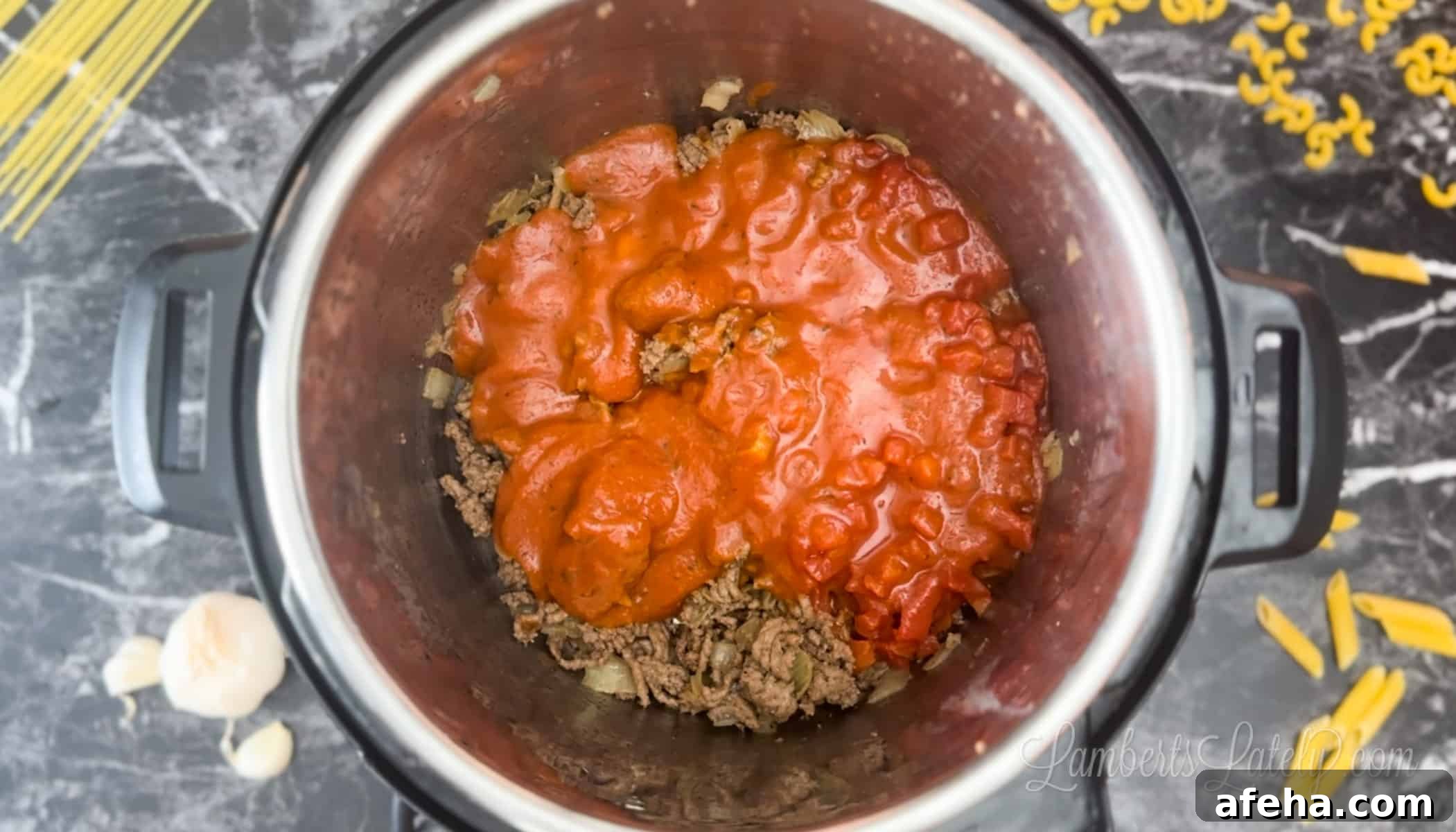 sauce over ground beef and onion in an instant pot.