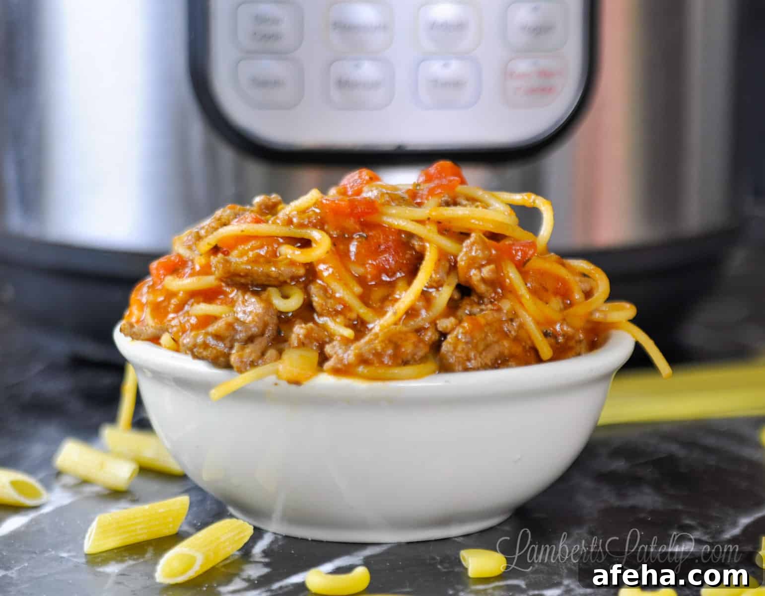 spaghetti in a bowl in front of an instant pot.