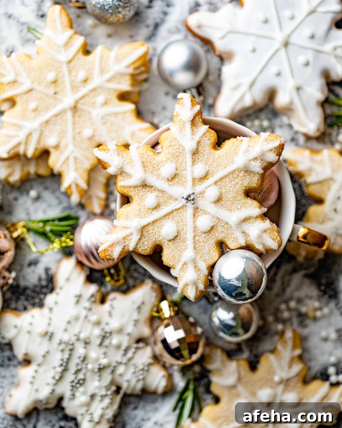 snowflake cookies arranged on top of a wooden table.