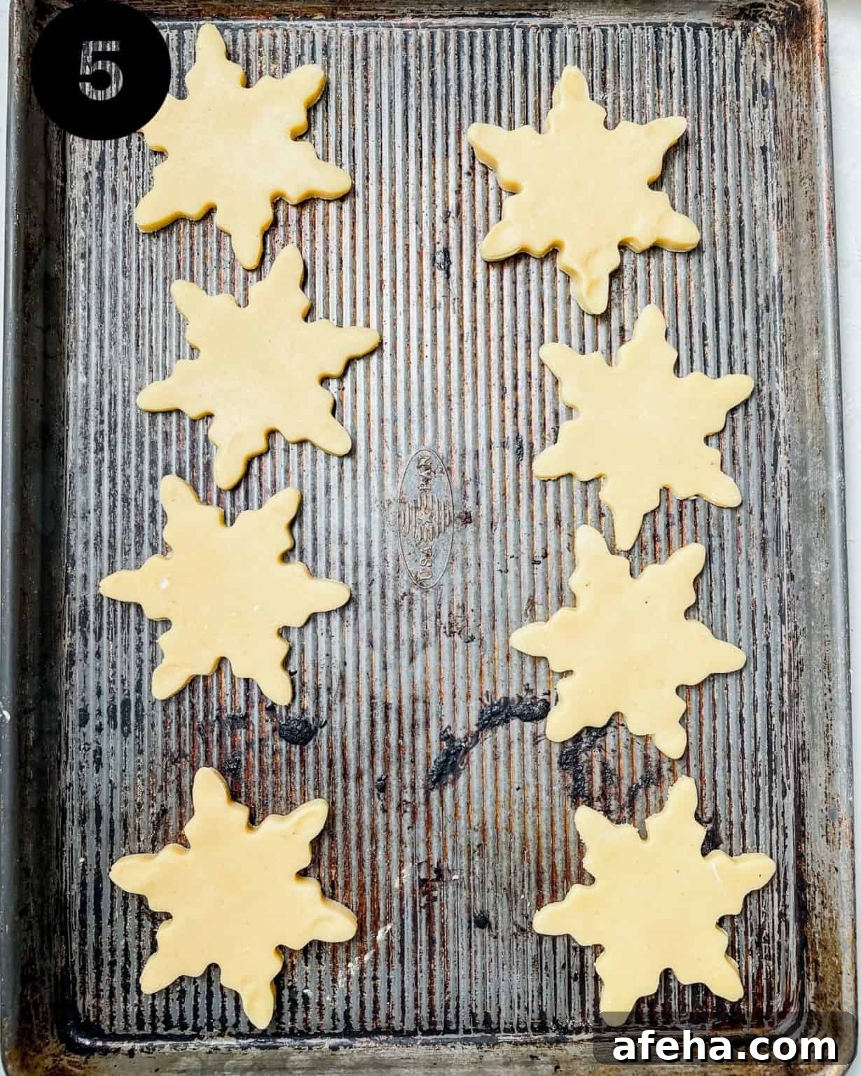 snowflake cookies on a baking sheet.