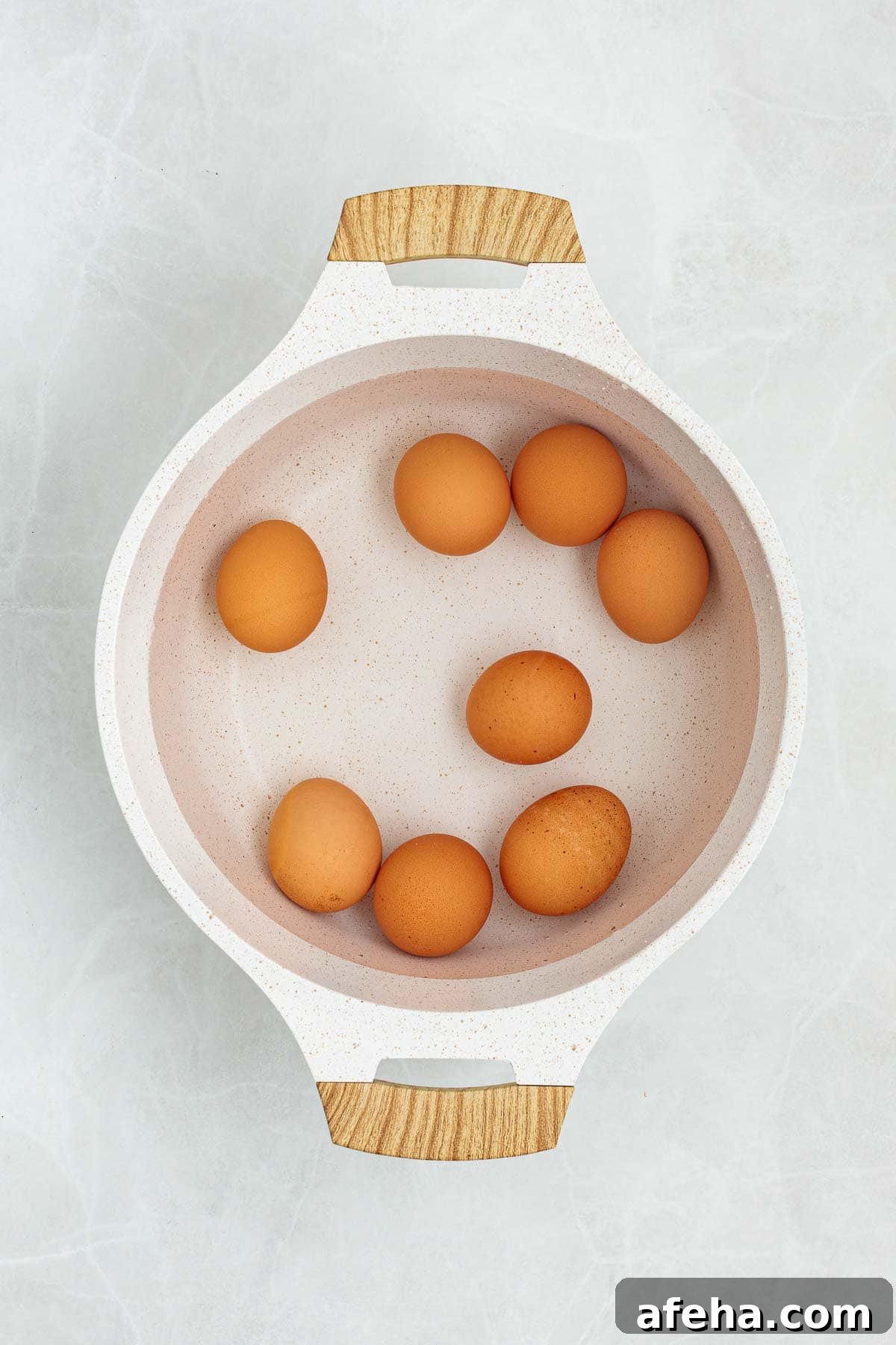 Eggs placed in a pot of water ready to be boiled, shown from above as part of the preparation process for egg salad.