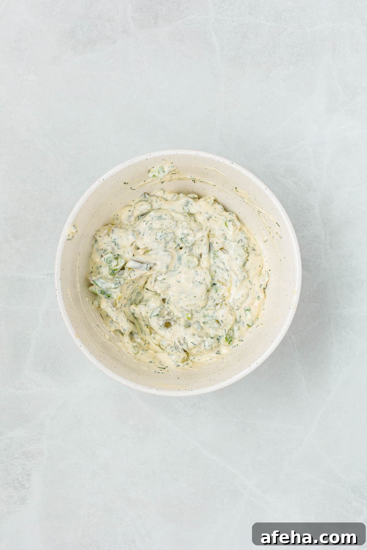 Creamy mixture with chopped pickles, herbs, and green onions stirred into the dressing, showing the base of dill pickle egg salad before adding eggs.