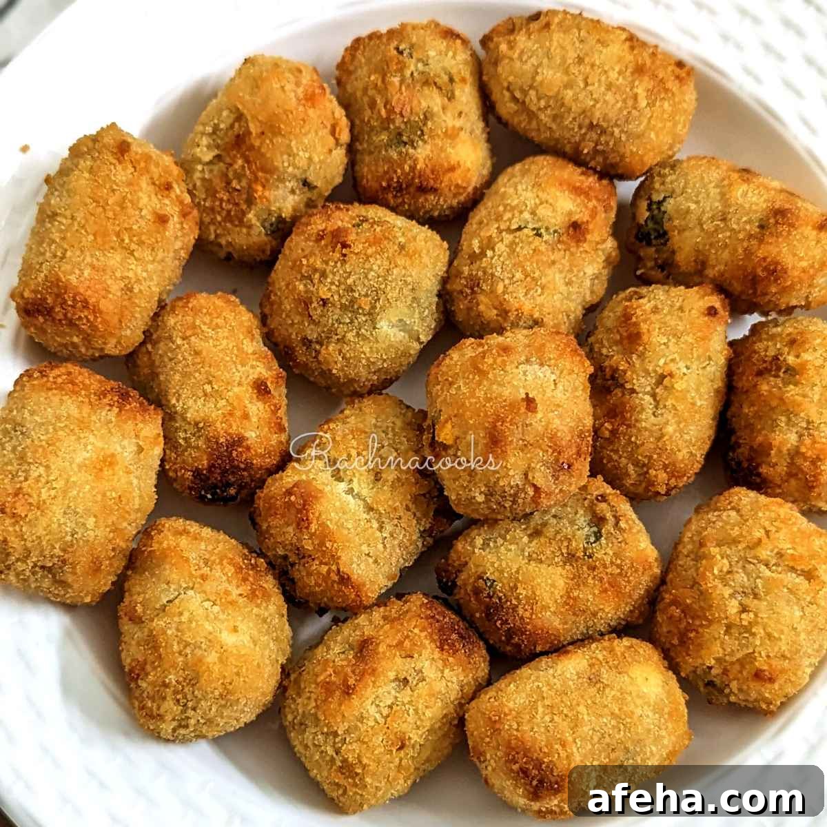 golden brown air fried veggie tots served on a white plate.