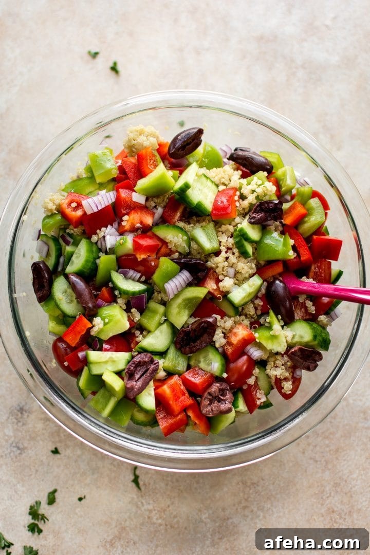 ingredients for Mediterranean quinoa salad in a glass mixing bowl