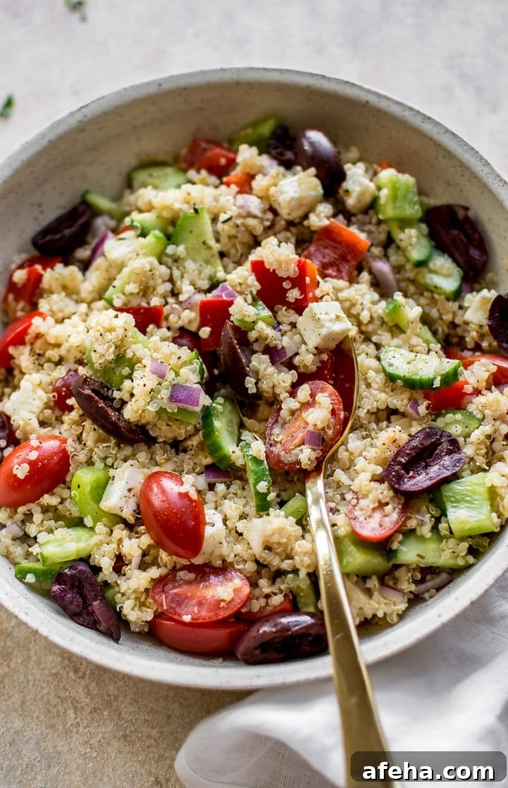 close-up of healthy Greek quinoa salad in a bowl with a spoon