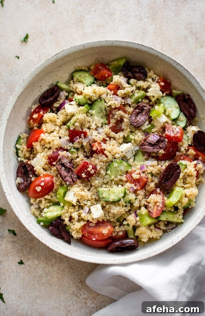 beige serving bowl with Mediterranean quinoa, olive, and tomato salad