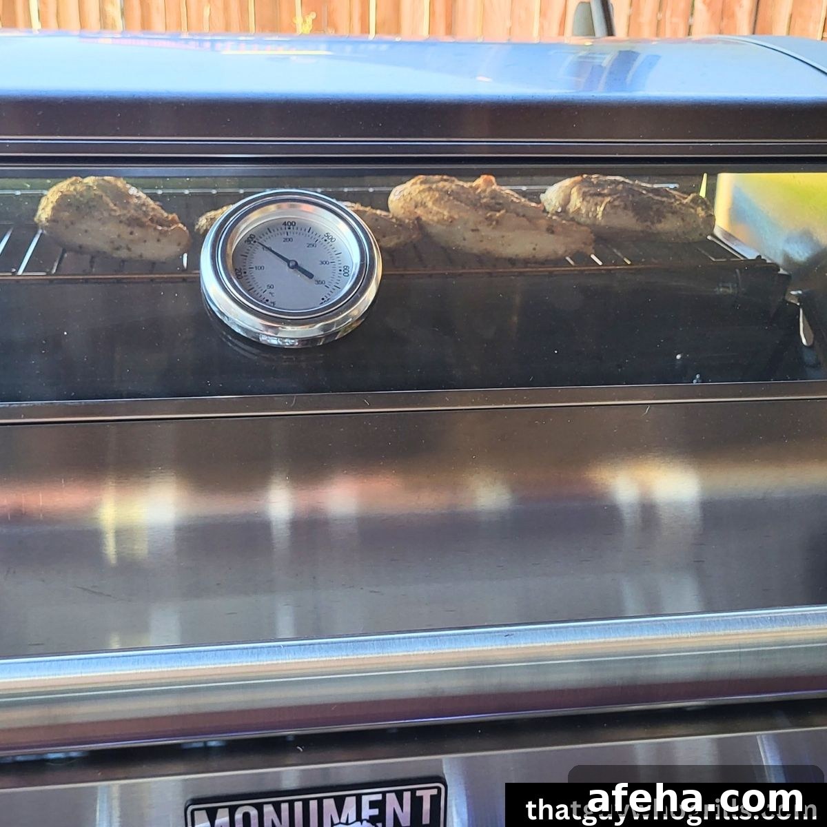 Chicken cooking on Monument Grills Stainless 35633 thru glass on lid