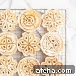 Powdered sugar dusted rosettes on a gold cooling rack.
