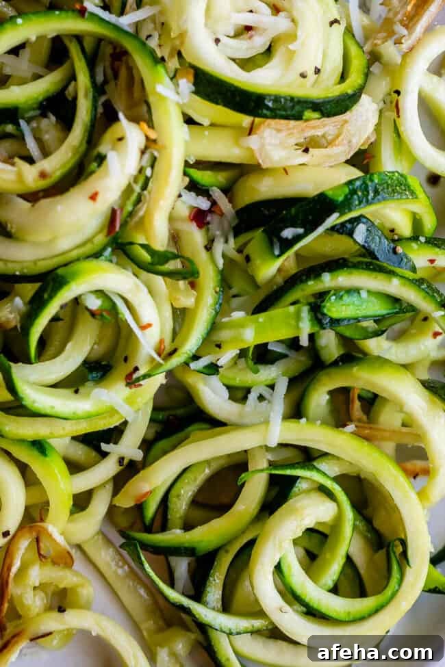 close up shot of curly zoodles with cheese.