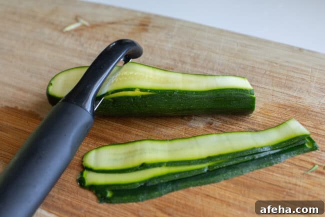 peeling zucchini into ribbons using a vegetable peeler.