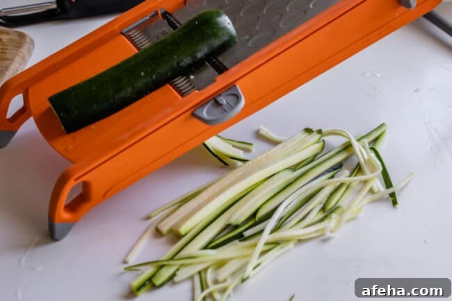 using a mandolin to make straight zucchini noodles.