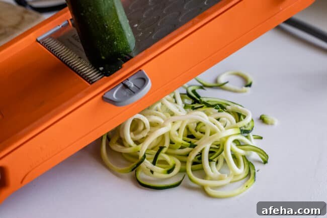 using a mandoline to make zucchini noodles.