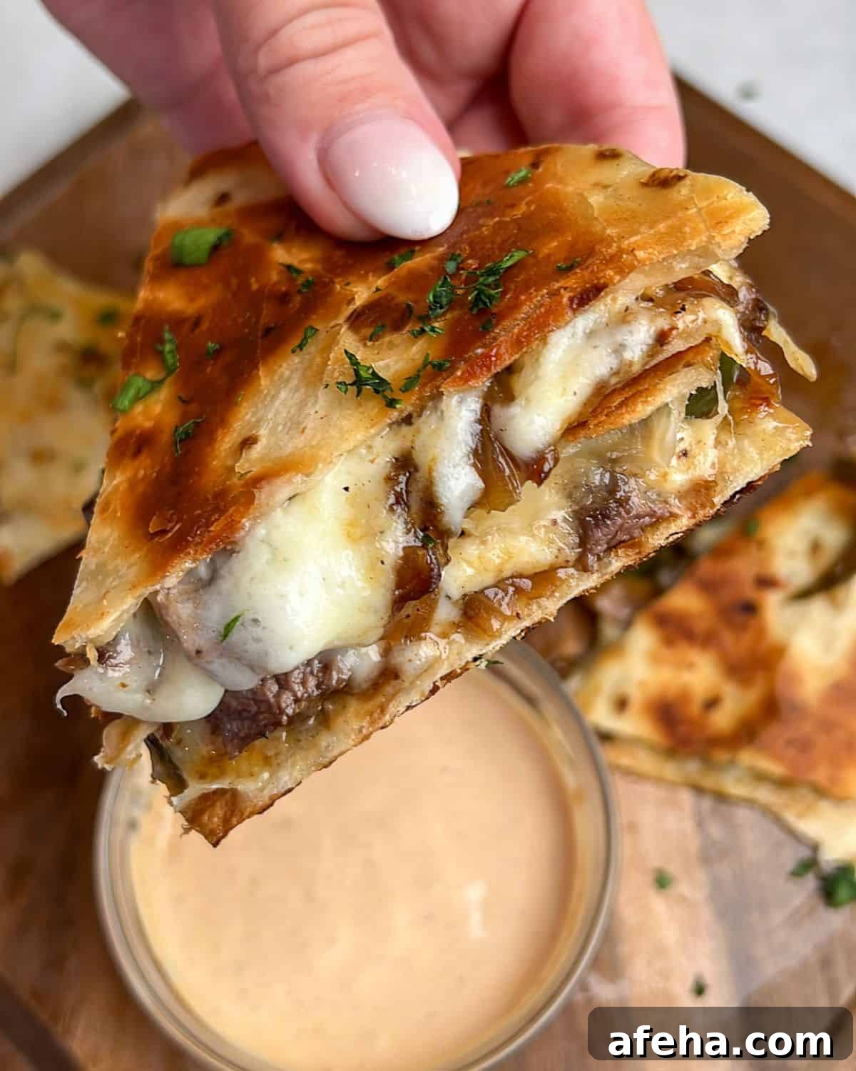 Smoky Chipotle Steak Quesadillas with Creamy Crema 2 steak quesadillas being held in hand