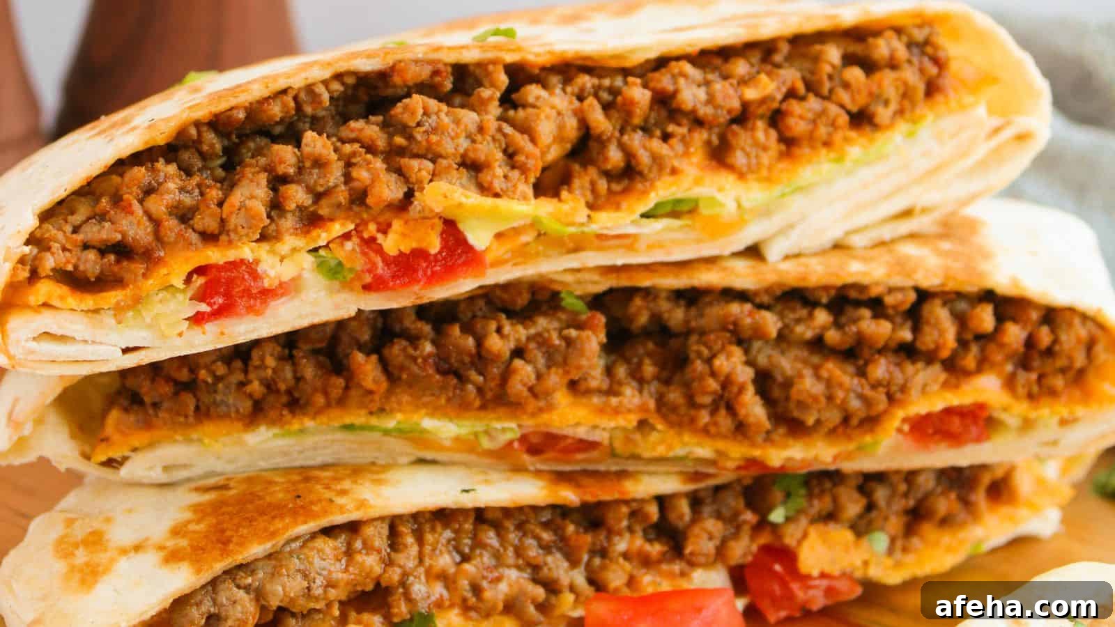 Three folded tortillas filled with seasoned ground meat, diced tomatoes, and melted cheese.