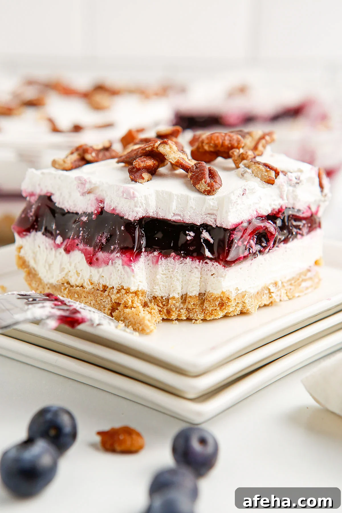 A slice of Blueberry Delight on a white plate.