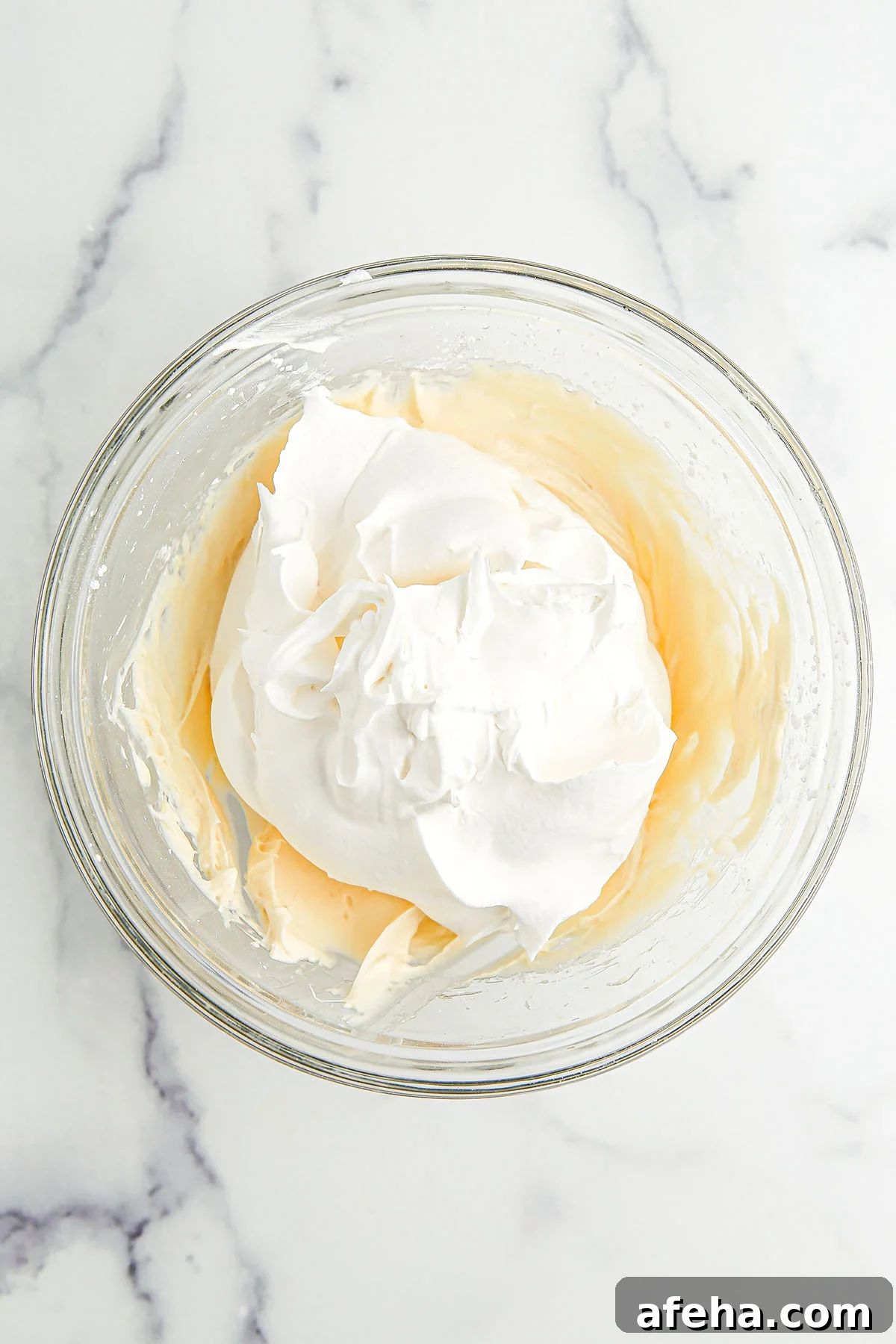 Whipped topping added to the cream cheese mixture in the mixing bowl.