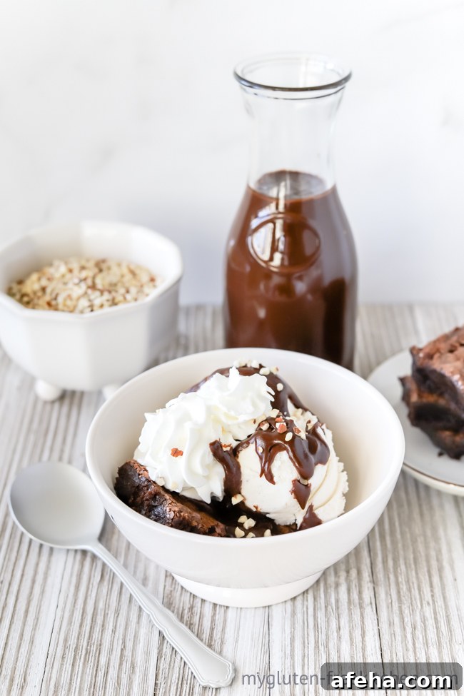 Gluten-free Hot Fudge Sundae in bowl with bowl of nuts and bottle of hot fudge