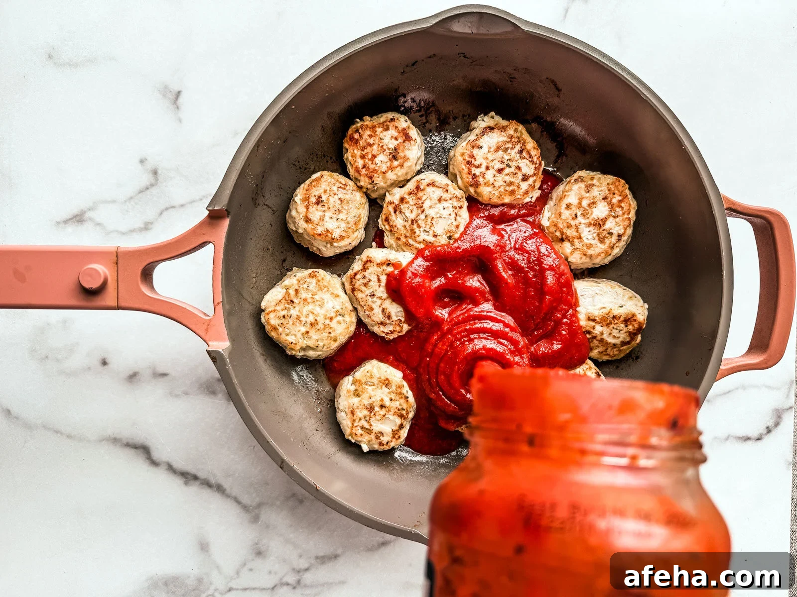 Savory Ground Chicken Meatballs with Tangy Tomato Sauce 5 Meatballs in pan being covered in sauce.