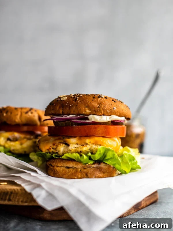 Savory Ground Chicken Meatballs with Tangy Tomato Sauce 9 Chicken burger with melted cheese on a serving platter.
