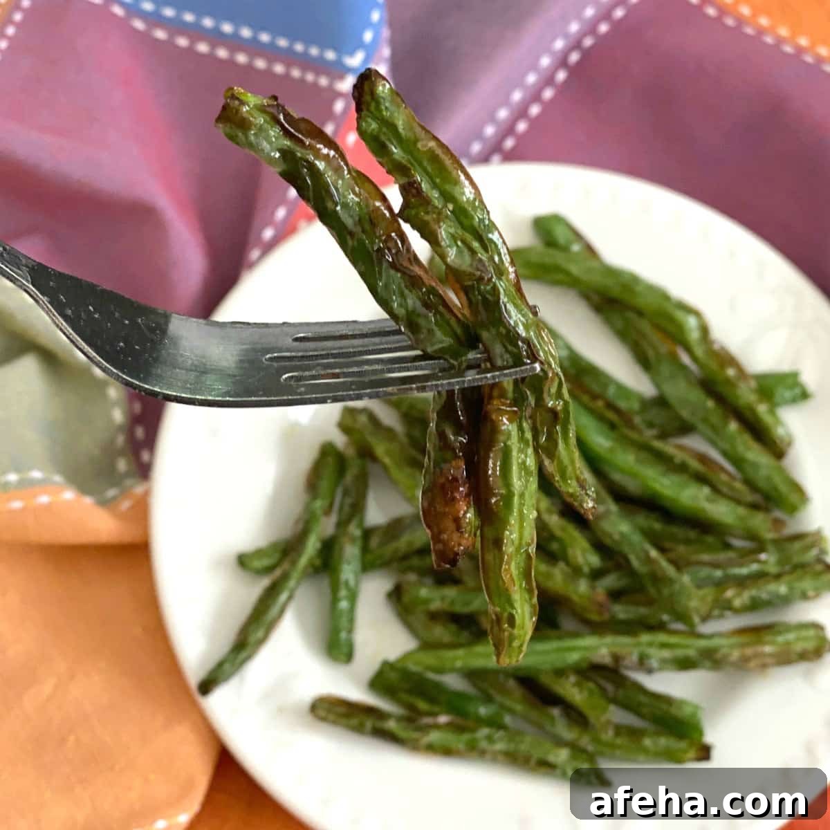 Crispy Roasted Green Beans (Air Fryer or Oven) 4 Fork with 3 green beans cooked in an air fryer