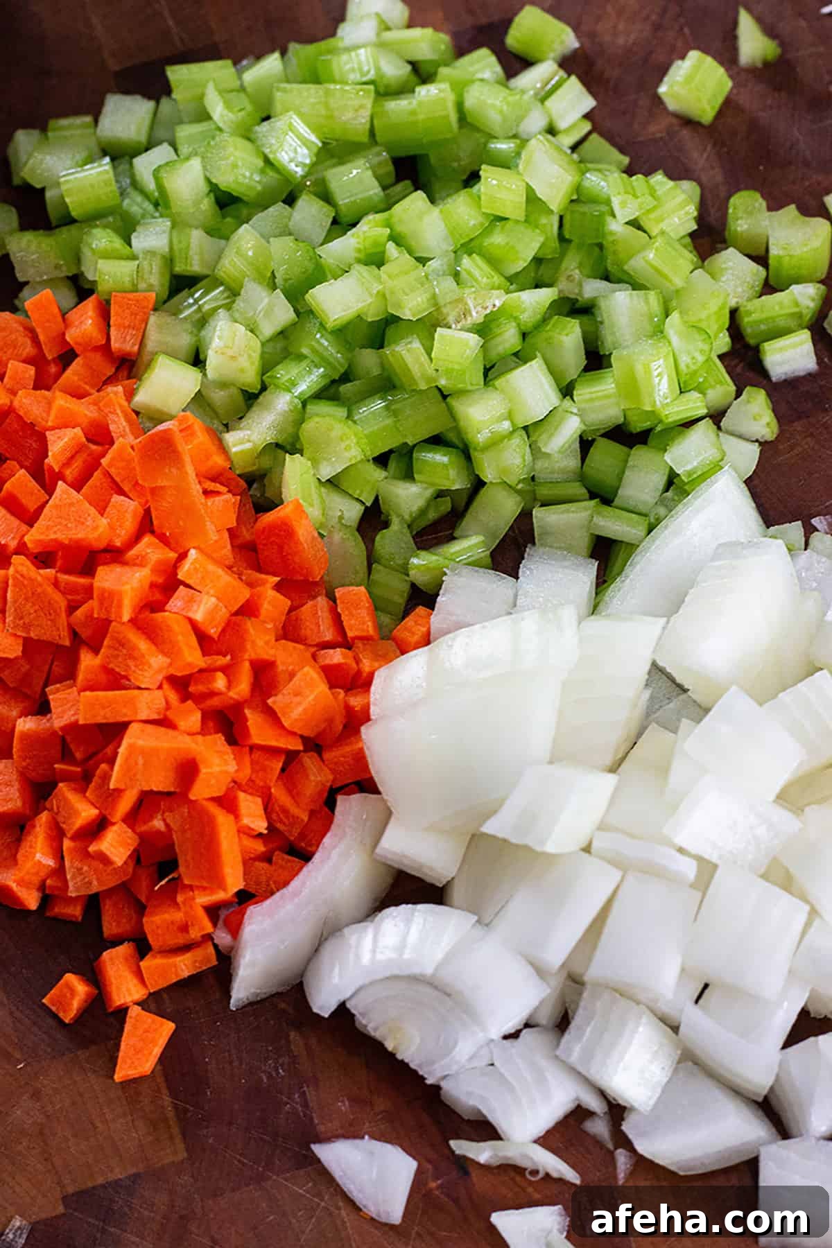 A pile of freshly cut veggies. Carrots, Onions and celery.
