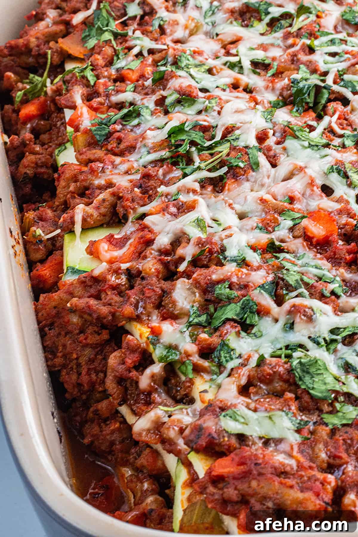 Freshly baked homemade zucchini lasagna with parmesan cheese and parsley.