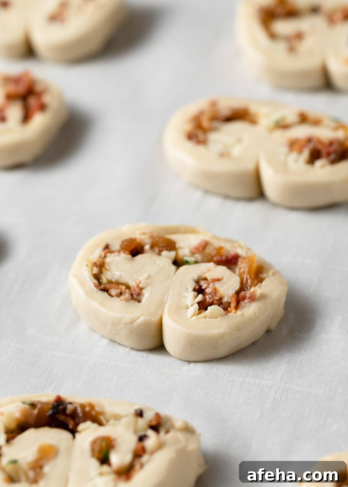 unbaked bacon palmiers on a parchment-lined baking sheet