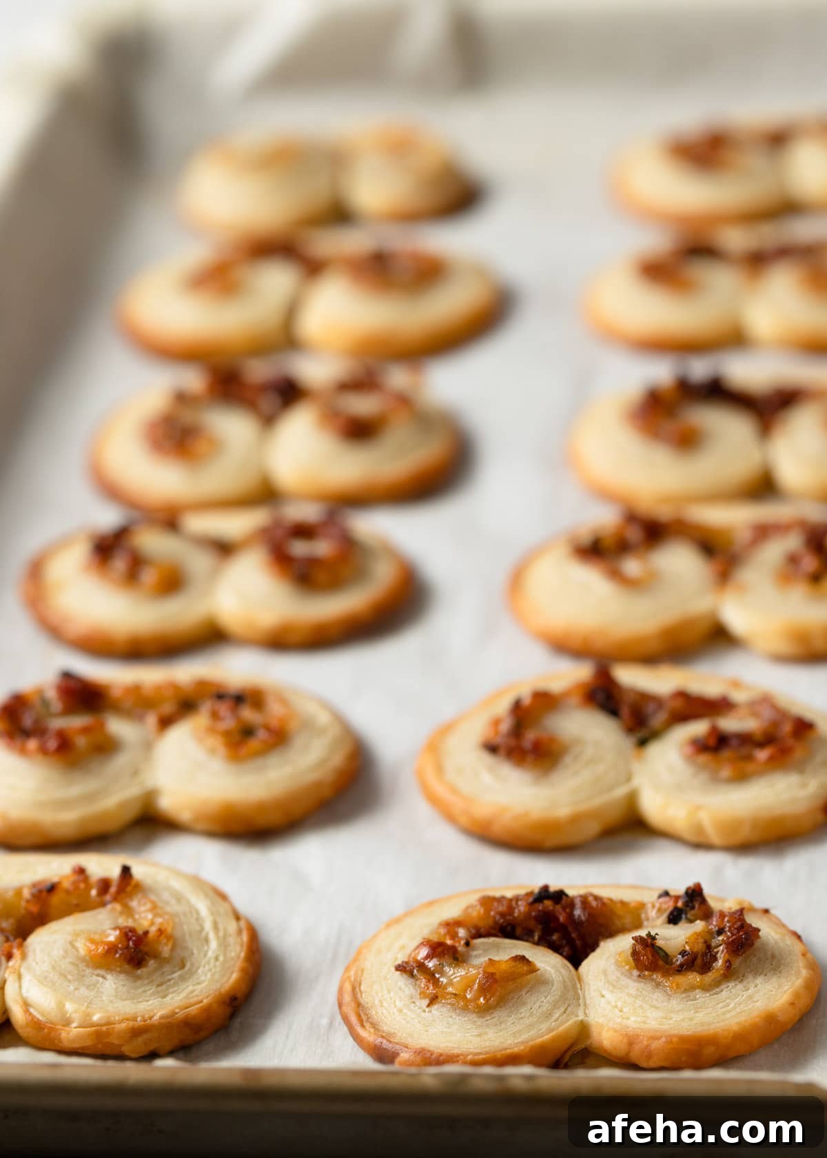 baked savory palmiers on a pachment-lined baking sheet