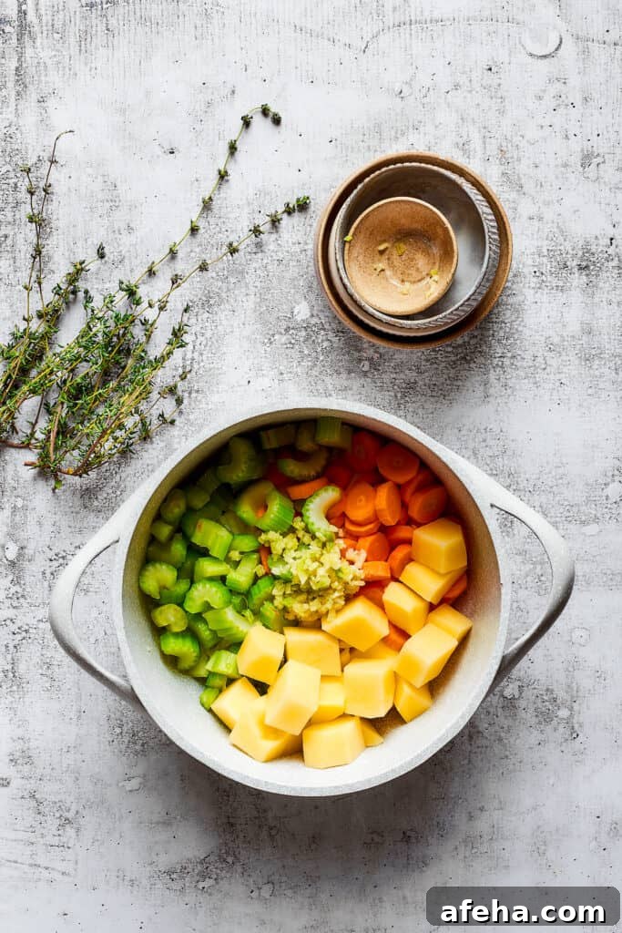 Hearty and comforting chicken pot pie soup has a rich and creamy broth, tender veggies, and juicy chicken, and is so easy to make. A pot filled with potatoes, celery, carrots, and onion