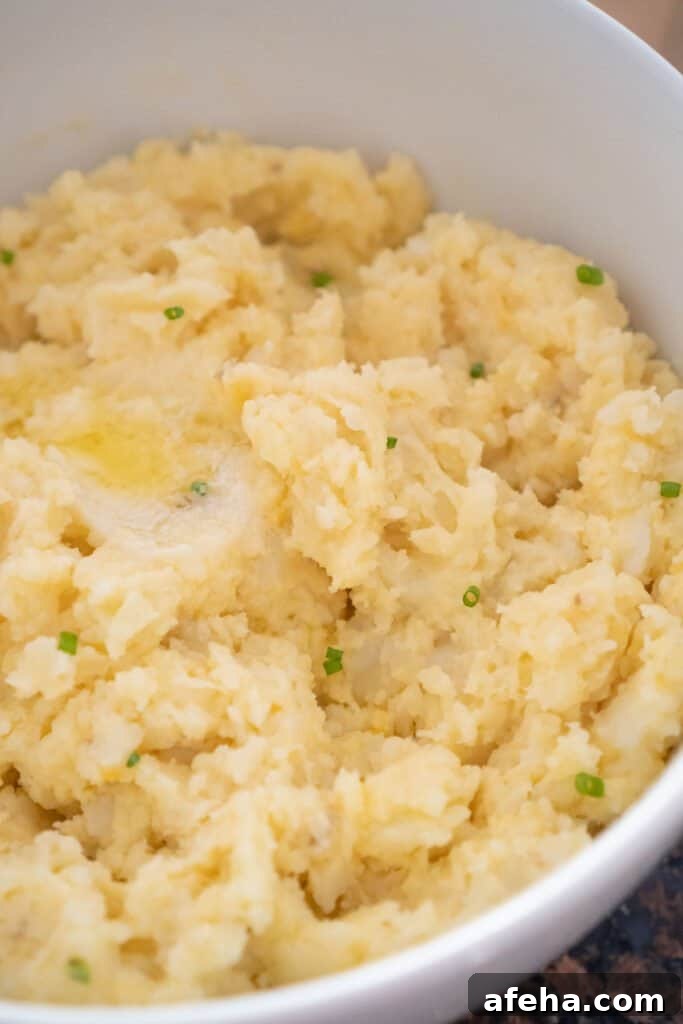 cheesy garlic mashed potatoes in white bowl