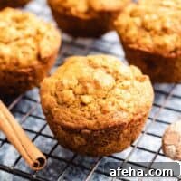 Four pumpkin oatmeal muffins on a cooling rack.