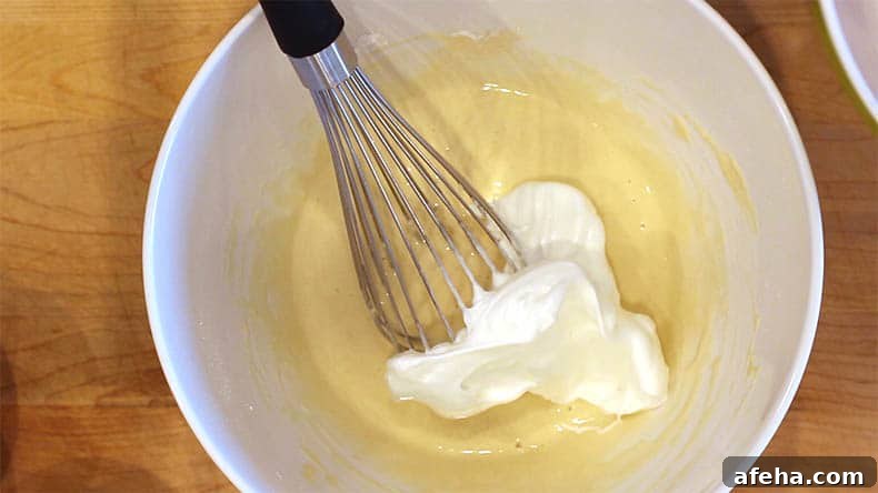 a whisk with meringue and pancake batter in a bowl