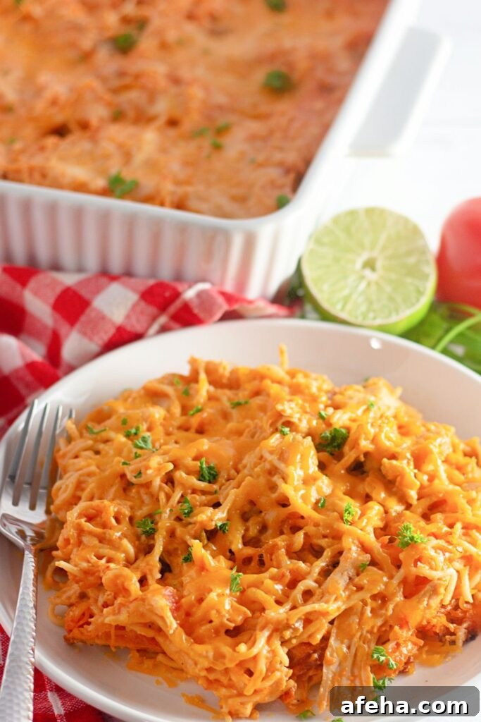 plate with a mexican pasta bake and then in the background a cut lime and casserole dish 