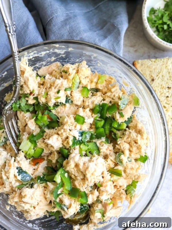 Tuna in a clear bowl with jalapeño and bread.