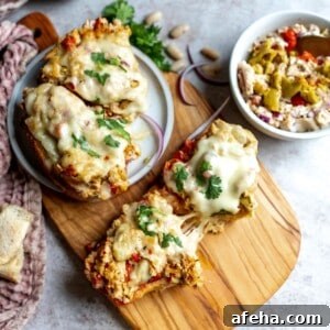 Wooden cutting board and white plate with tuna salad and bread.