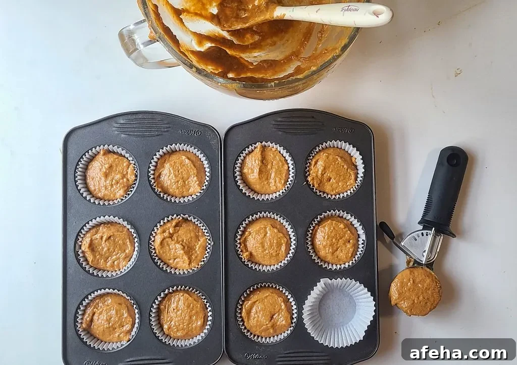 pumpkin crumb muffin batter added to the muffin tin