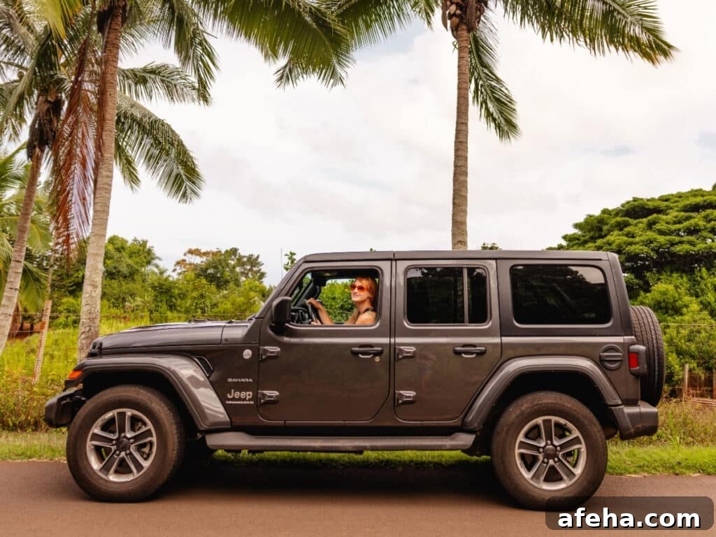 A black jeep rental car on the palm-filled streets of Oʻahu, Hawaiʻi.