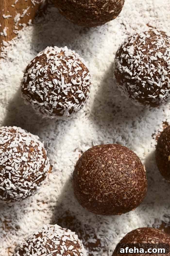 Coconut rum balls being rolled and coated in coconut