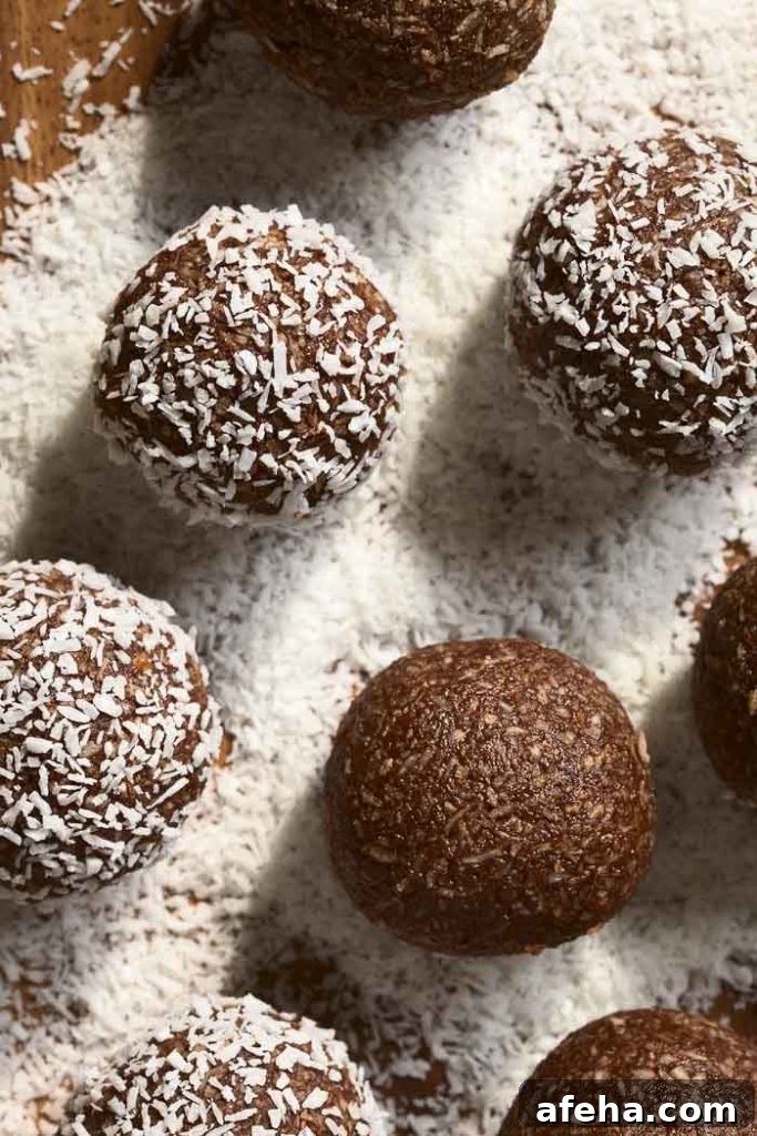 Coconut rum balls being rolled and coated in coconut