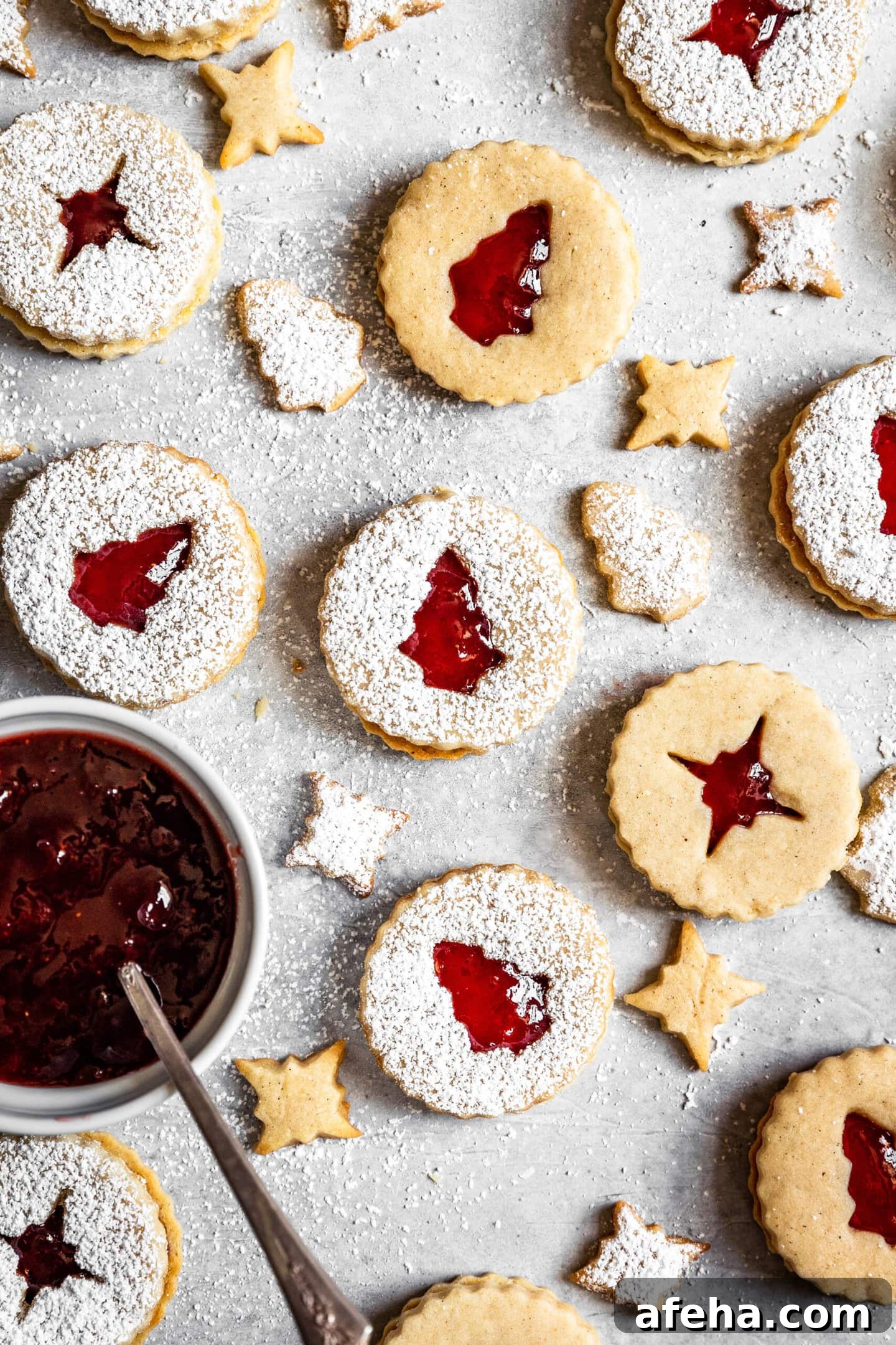 Strawberry Cardamom Linzer Cookies next to a small bowl of strawberry preserves