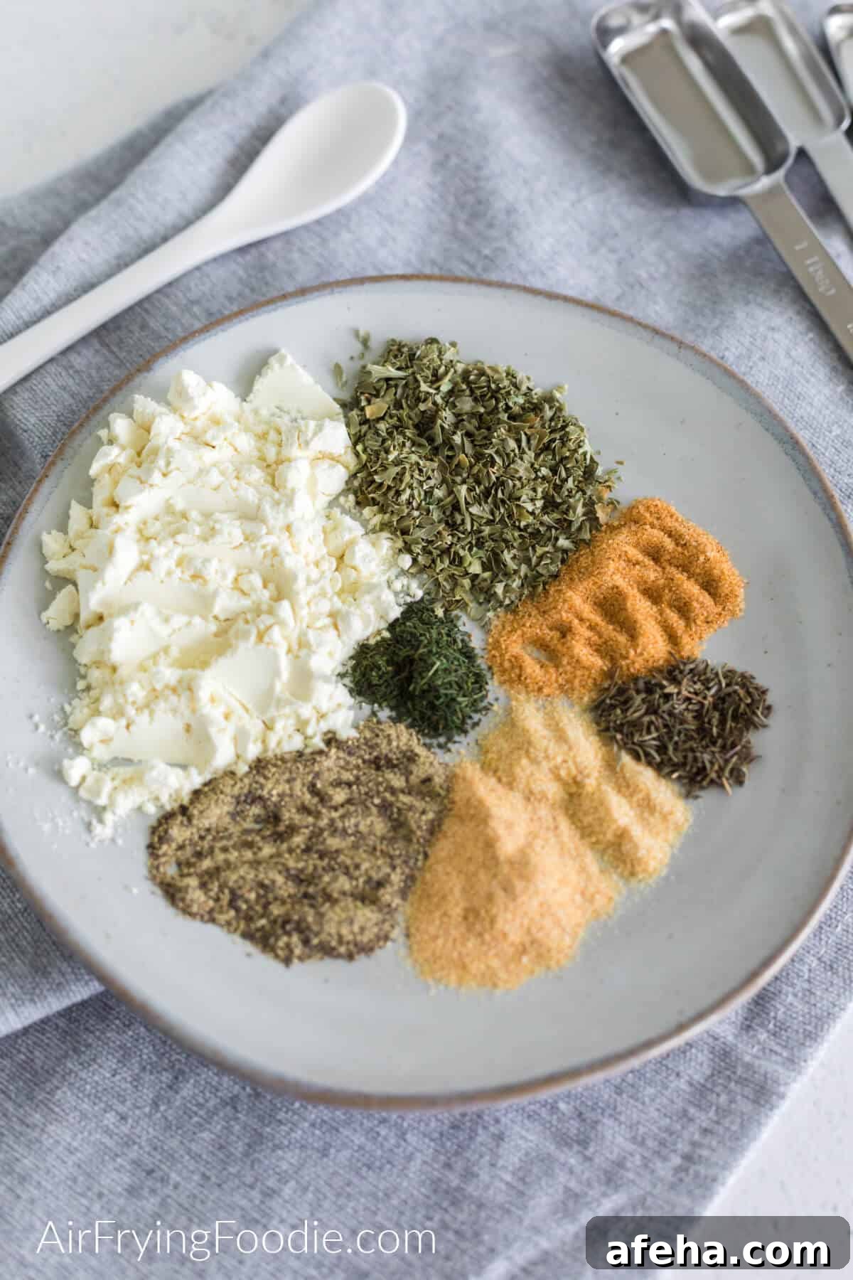 Ingredients needed to make Homemade Ranch seasoning measured out into portions before mixing together and blending into the seasoning.