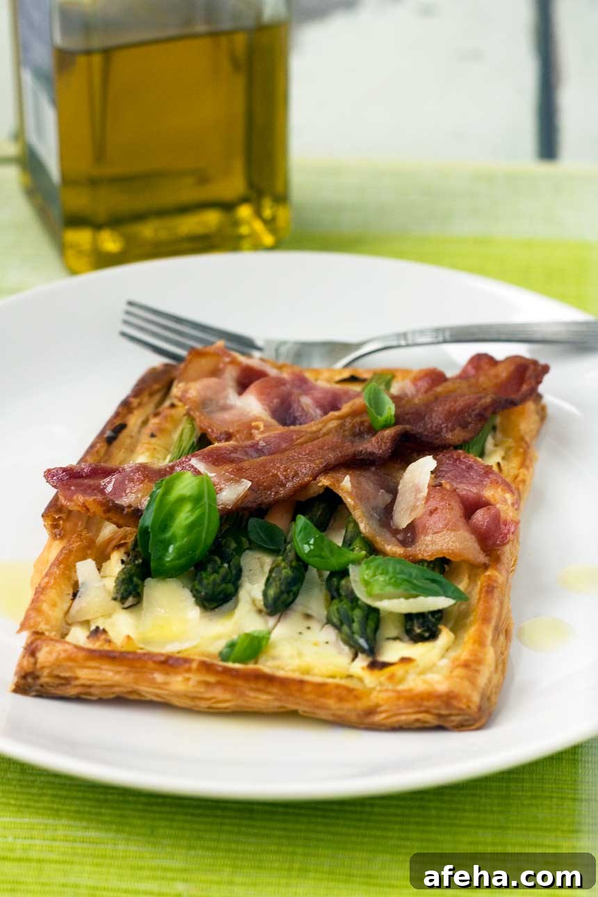 asparagus brunch tart with parmesan & basil on a white plate and on a green background
