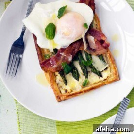 asparagus brunch tart with parmesan and basil with an egg on it on a white plate with a fork and on a green place mat.
