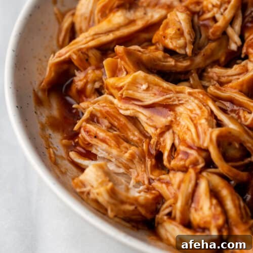 Pulled chicken covered in bbq sauce in a serving dish.