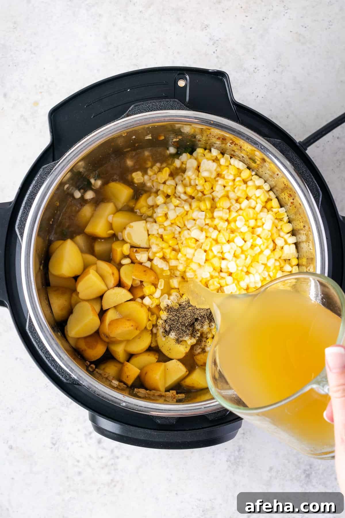 Potatoes, corn, salt, pepper and chicken broth being added to the instant pot.